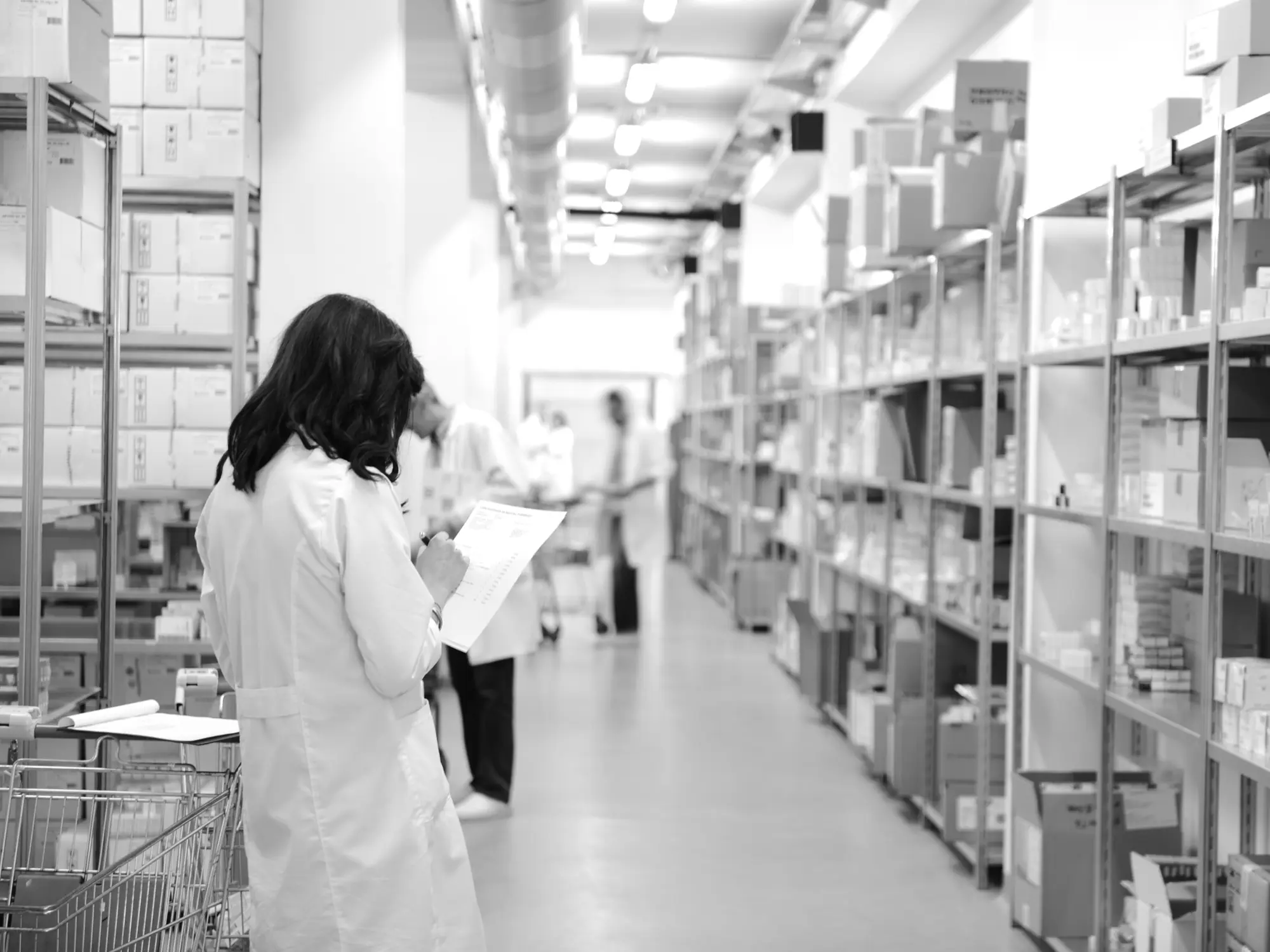 White-coated staff checking inventory in a medical supply warehouse