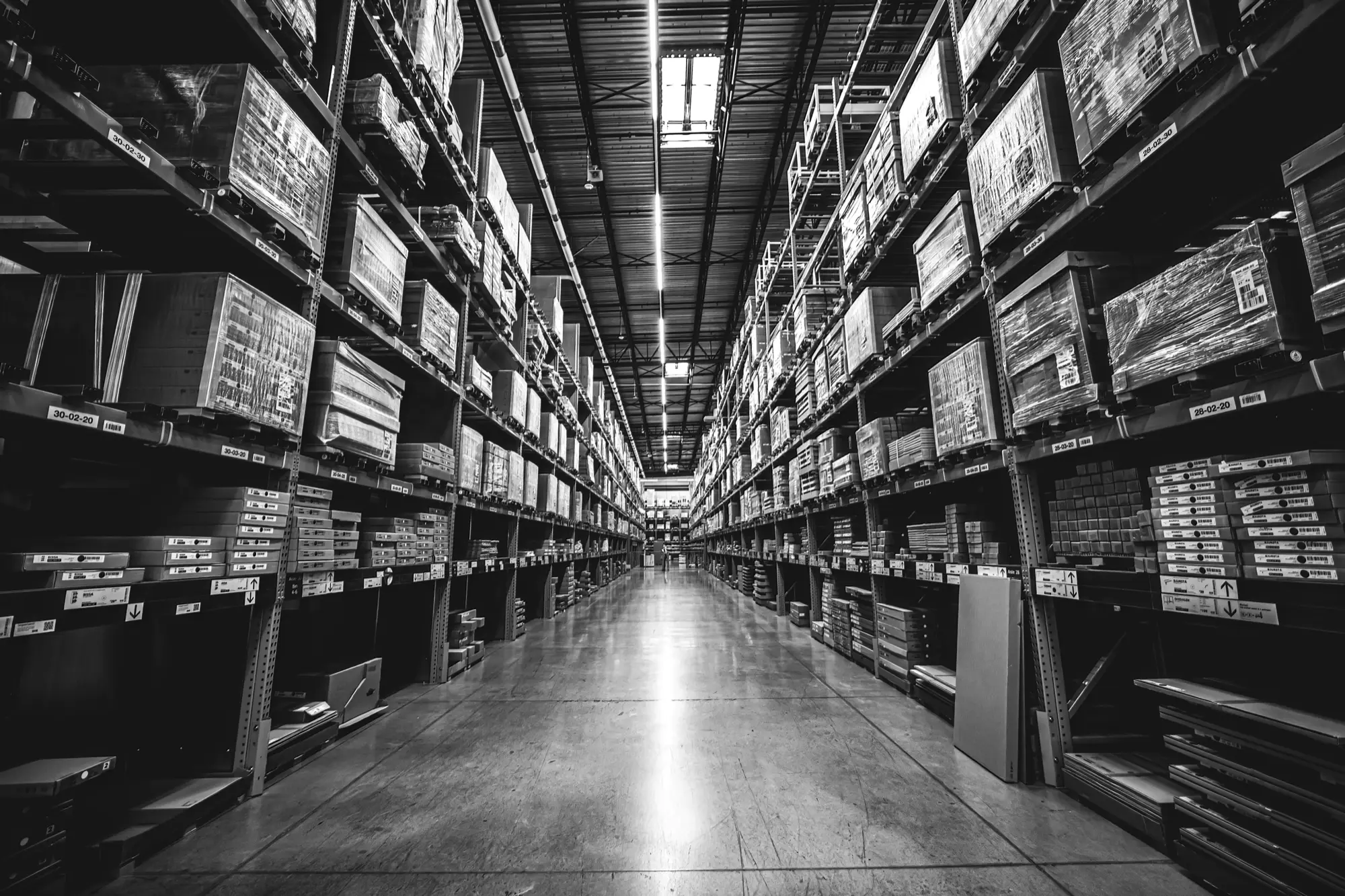 Warehouse racking aisle stretching toward the horizon, shot in black and white